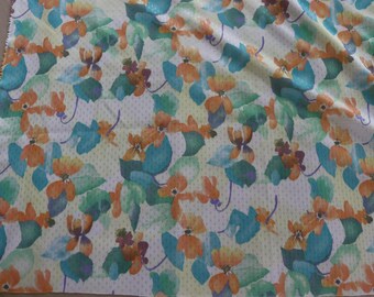 Tejido floral ligero de punto doble de los años 70 - Tejido de punto doble de poliéster vintage con flores de color naranja pálido y hojas verdes para ropa retro o patchwork