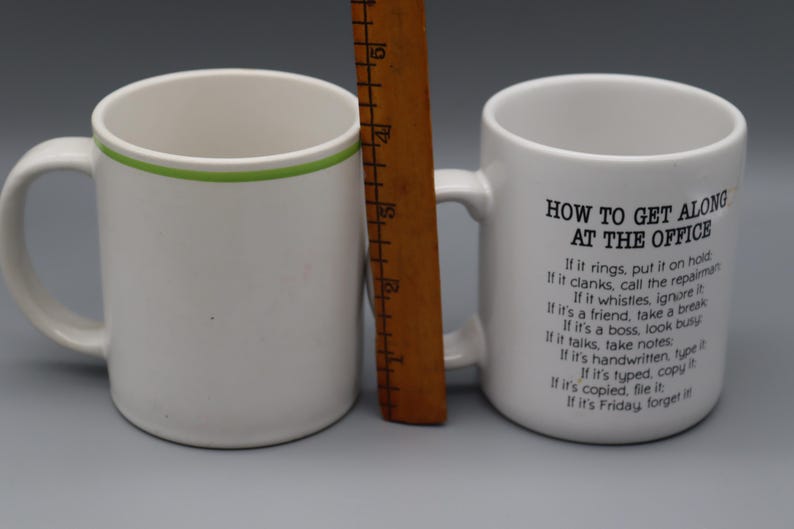 May include: A set of three ceramic mugs with a speckled, matte finish. Each mug features a different color: light blue, cream, and gray. The mugs have a simple, modern design and a comfortable handle.