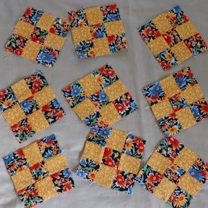 May include: Nine yellow and black patchwork squares with a floral pattern. Each square is made up of nine smaller squares, with alternating colors and patterns.