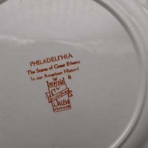 K&ouml;nnte beinhalten: Wei&szlig;er Teller mit braunem Text "PHILADELPHIA The Scene of Great Events In our American History" und dem Logo Imperial & Salem Chinaco.