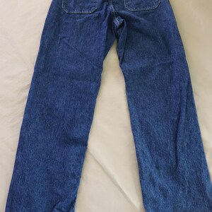 Op de afbeelding: Blauwe jeans van denim met twee achterzakken. De jeans hebben een klassiek ontwerp met vijf zakken en een rechte pijp. De denimstof heeft een medium wassing en een licht vervaagde uitstraling. De jeans liggen plat op een witte ondergrond.