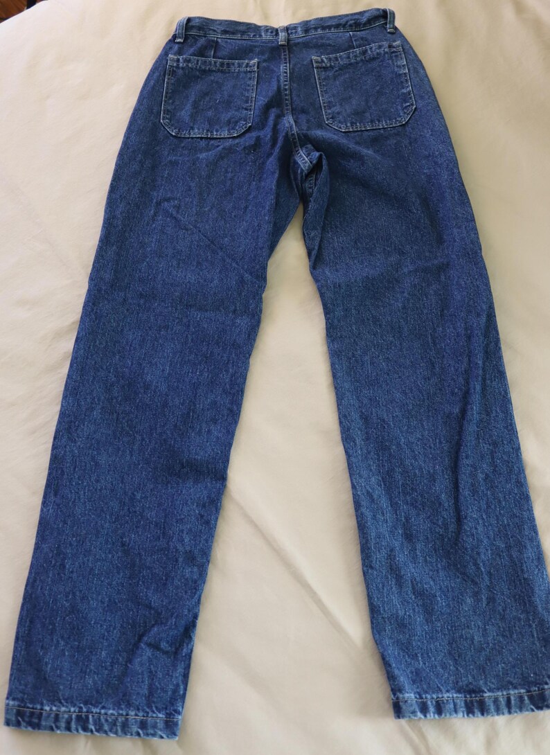 Op de afbeelding: Blauwe jeans van denim met twee achterzakken. De jeans hebben een klassiek ontwerp met vijf zakken en een rechte pijp. De denimstof heeft een medium wassing en een licht vervaagde uitstraling. De jeans liggen plat op een witte ondergrond.