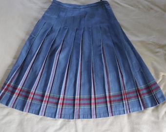 May include: A blue pleated skirt with a tartan trim. The skirt has a high waist and a flared silhouette.