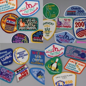 May include: A collection of colorful embroidered patches featuring bowling-related designs. The patches feature various logos, including "WIBC", "ABC", and "League Champion". Some patches also include text such as "75 pins over average", "All Spare Game", and "Crescent Bowl Bowling Green KY".