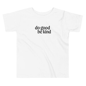May include: White toddler t-shirt with black text that reads "do good be kind".