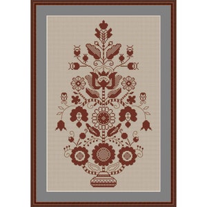 Puede incluir: Un diseño de bordado de punto de cruz marrón y blanco de un arreglo floral estilizado en un jarrón. El diseño presenta una flor central con una corona, rodeada de flores y hojas más pequeñas.