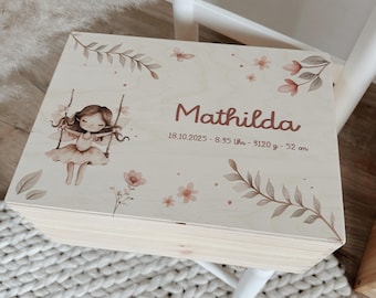May include: A rectangular wooden keepsake box featuring a printed illustration of a fairy on a swing, floral accents, and the name Mathilda. Text includes 18.10.2025 - 8:35 Uhr - 3120 g - 52 cm, detailing birth date, time, weight, and length.
