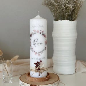 Świeca chrzcielna z wiankiem z kwiatów/pętelką z kwiatów w odcieniach bordowym, różowym i przygaszonej róży, z szydełkową lamówką i suszonymi kwiatami, oraz opcjonalnym wierszykiem chrzcielnym.