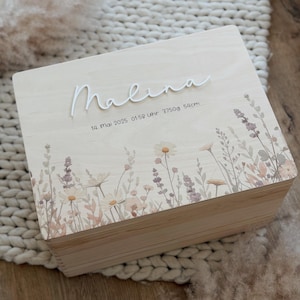 Può includere: Scatola ricordo in legno chiaro con il nome "Malina" in corsivo. La scatola è decorata con un motivo floreale in tenui colori pastello. È visibile anche il testo "14. Mai 2025 01:58 Uhr 3750g 54cm".