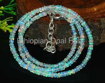 May include: A multi-strand necklace made of small, iridescent opal beads. The necklace is silver in color and has a silver clasp.