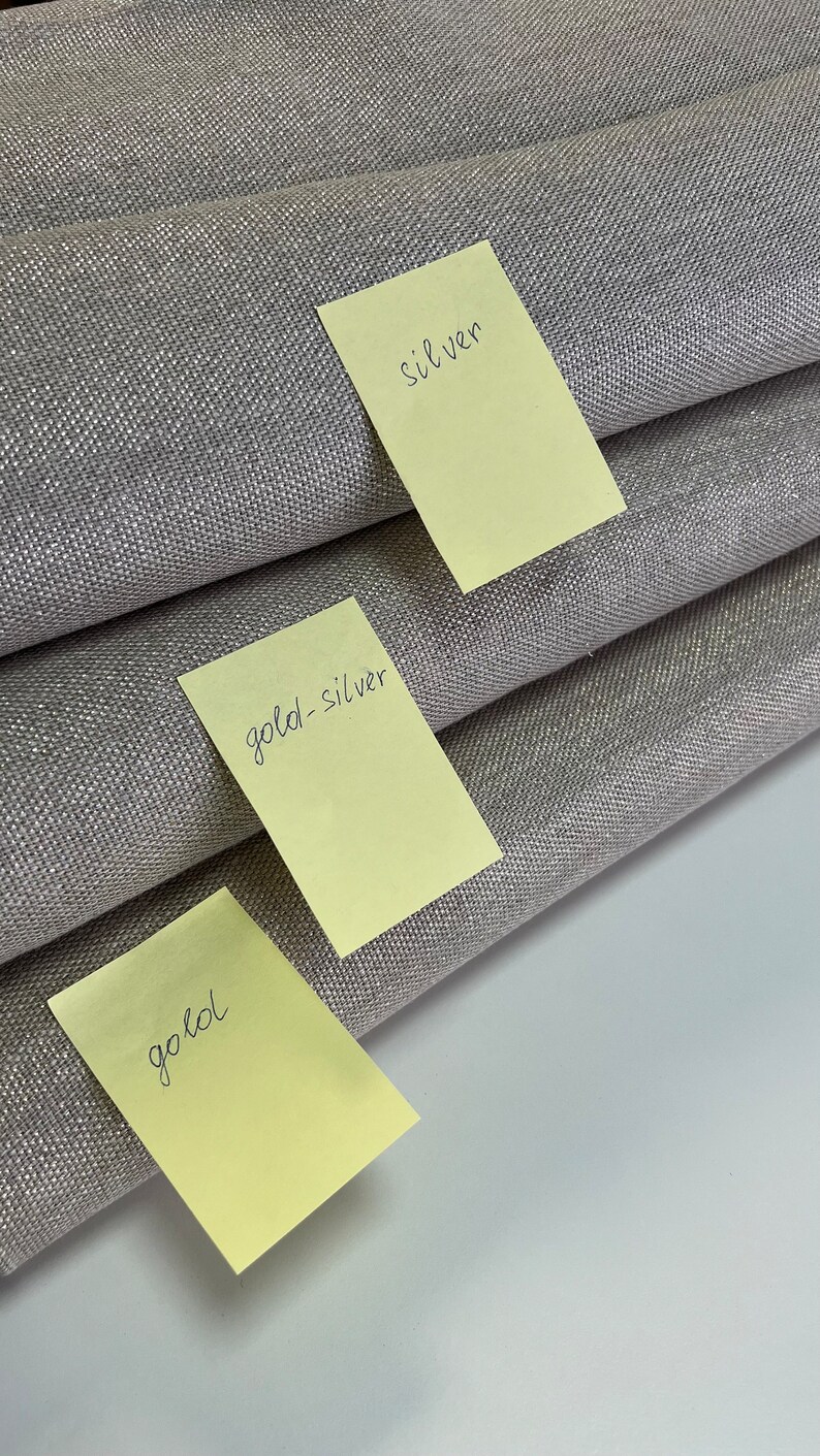 May include: Three fabric swatches labeled with sticky notes. The top swatch is labeled "silver", the middle swatch is labeled "gold-silver", and the bottom swatch is labeled "gold".