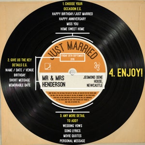 Peut inclure: Un disque vinyle noir avec une &eacute;tiquette jaune et orange qui dit "Just Married" avec la date "Friday 25th September 2015". L'&eacute;tiquette comprend &eacute;galement les noms "Mr. & Mrs. Henderson" et l'emplacement "Jesmond Dene House, Newcastle".
