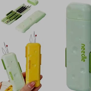 May include: A selection of sewing needle tools in different colours. The image shows a light green case with the word "needle" printed on the side, and a yellow case with the same text. Other tools are also visible.