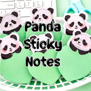 May include: A selection of heart-shaped, pale green sticky notes featuring panda bear illustrations. Each panda has black and white fur and pink cheeks. The words "Panda Sticky Notes" are written in black.