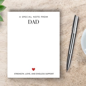 May include: A white notepad with the text "A special note from Dad" at the top and "Strength, love, and endless support" at the bottom. A red heart is between the words "love" and "and".
