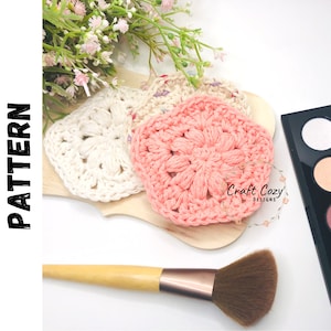 May include: A digital crochet pattern for making a set of three crocheted makeup remover pads. The pads are in white and pink and are shown on a wooden surface with a makeup brush and a makeup palette. The text "Craft Cozy Designs" is visible in the image.