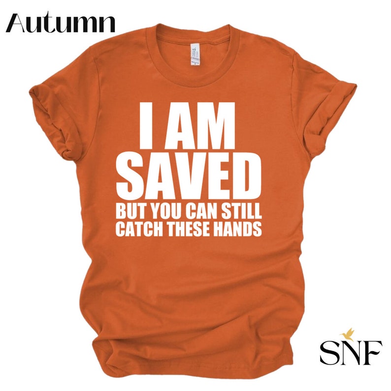 May include: Orange t-shirt with white text that reads "I am saved but you can still catch these hands".