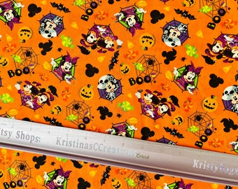 May include: Orange Halloween fabric with a repeating pattern of cartoon characters, pumpkins, spiderwebs, bats, and the word "BOO." Mickey and Minnie Mouse are dressed in Halloween costumes. This fabric is suitable for various craft projects and is sold by the metre.