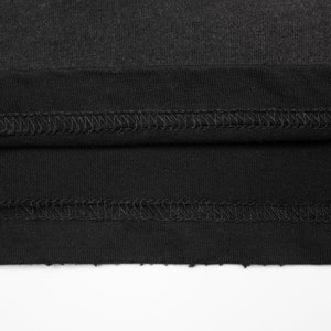May include: A black fabric garment featuring a double-stitched hem with visible thread detailing. The edge of the fabric is raw and unfinished, showing a textured, slightly frayed appearance along the bottom border of the material.