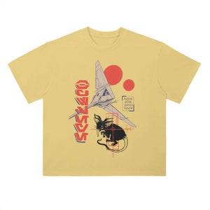 May include: A yellow t-shirt featuring a black and white illustration of a spaceship and a creature with large ears. The text "CONQUEST" is printed vertically in red on the left side of the shirt. There are two red circles in the background.