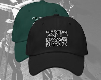 May include: Two baseball caps, one green and one black, with white embroidered text that reads "DIRECTED AND PRODUCED BY STANLEY KUBRICK".