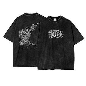 May include: Two black t-shirts with a white graphic print. One shirt features an alien creature with the word "ALIEN" printed below. The other shirt features the word "ALIEN" in a stylized font.