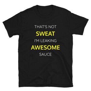 Może przedstawiać: Czarny T-shirt z białym tekstem, który brzmi "That's not sweat I'm leaking awesome sauce". Tekst "sweat" i "awesome" jest żółty.