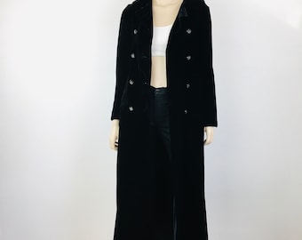 May include: A long black velvet coat with a double breasted closure and silver buttons.