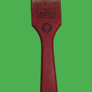 May include: Red Devil brand scraper with a red wooden handle and a metal blade. The scraper has a red devil logo with the text "Red Devil Scraper" and "Irvington, N.J. U.S.A. Pat'd".