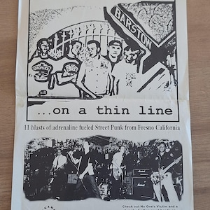 May include: Black and white flyer for the band "No One's Victim" with the text "...on a thin line". The flyer features band members and a live performance photo. The flyer also promotes a "PURE PUNK" Sampler CD.
