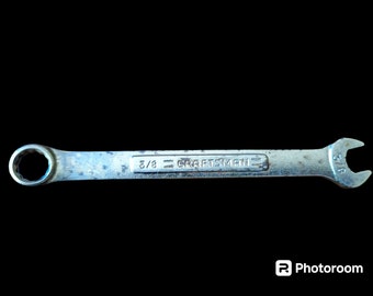 May include: A silver wrench with a black background. The wrench is labeled "3/8" and "CRAFTSMAN" on the handle.