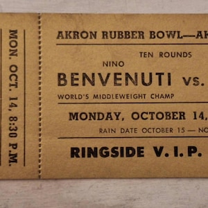 May include: Vintage boxing match ticket from the Akron Rubber Bowl in Akron, Ohio. The ticket is tan with black text, featuring the names Benvenuti vs. Baird, the date October 14, and Ringside V.I.P. information.