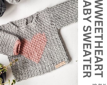 Op de afbeelding: Een grijze gehaakte babytrui met een roze hart op de voorkant. De trui heeft een klein bruin leren label met de tekst "CBK NZ". De afbeelding wordt vergezeld door de tekst "Sweetheart Baby Sweater 10 Ply PDF Pattern".