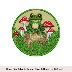 May include: Embroidered patch featuring a green frog with red eyes, sitting on a tree stump, surrounded by red and white mushrooms and green foliage. The patch is circular with a green border.