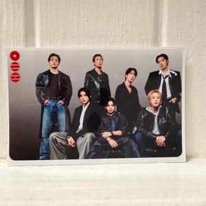 Puede incluir: Tarjeta rectangular con un grupo de siete personas. Todos visten diferentes atuendos, incluyendo chaquetas de cuero negras, blazers y vaqueros. La tarjeta tiene un borde blanco y un dise&ntilde;o rojo en la esquina superior izquierda. El fondo es un degradado de gris.