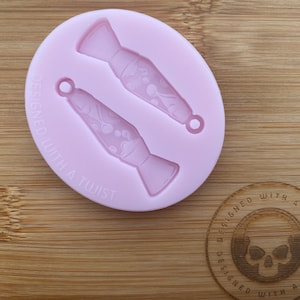 May include: Pink silicone mold with two lava lamp shapes. The mold has the text "Designed with a twist" on the side.