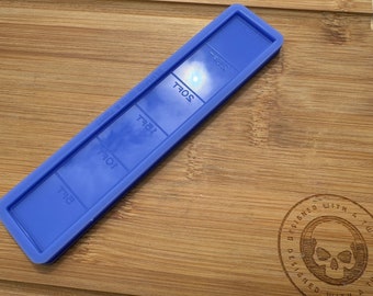 May include: A blue silicone mold with five rectangular sections. Each section has a number printed on it: 7/8, 1/0, 1/2, 1/4, and 2/4. The mold is on a wooden surface.