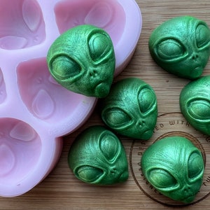 Puede incluir: Seis moldes de silicona verde en forma de extraterrestre con una bandeja de silicona rosa. Los moldes están diseñados para crear jabones, velas u otras manualidades con forma de extraterrestre.