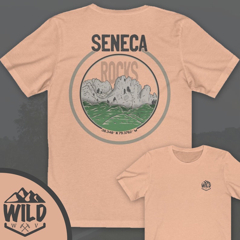 May include: A peach-colored t-shirt with a circular graphic on the back. The graphic features a mountain range with the text "Seneca Rocks" and coordinates "38.348&deg; N 79.3762&deg; W". The front of the shirt has a small logo with the text "WILD" in a mountain range design.
