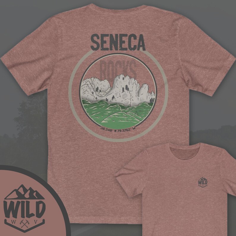 May include: A heather red t-shirt with a circular graphic on the back. The graphic features a mountain range with the text "Seneca Rocks" and coordinates "38.348 N 79.3762 W". The front of the shirt has a small logo with the text "WILD" and a stylized axe and pickaxe.