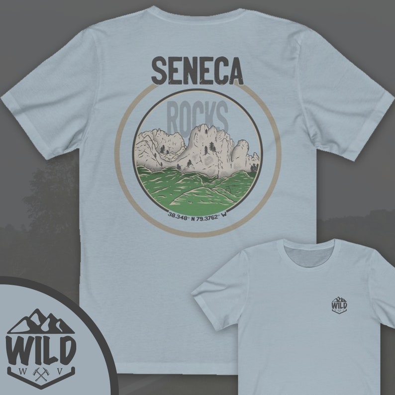May include: Light blue t-shirt with a circular graphic on the back. The graphic features a mountain range with the text "Seneca Rocks" and coordinates "38.348 N 79.3762 W". The front of the shirt has a small logo with the text "WILD" and a mountain range graphic.