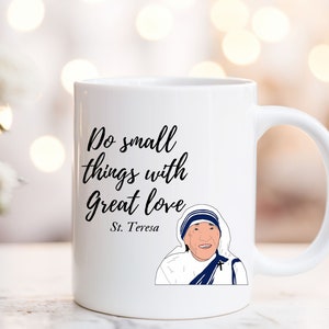 May include: White ceramic mug with a black quote that reads "Do small things with great love - St. Teresa". An illustration of Mother Teresa is on the mug.