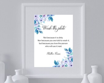 Könnte beinhalten: Ein weißer gerahmter Druck mit einem blauen und weißen Blumendesign. Der Druck zeigt ein Zitat von Mutter Teresa: "Wasche den Teller. Nicht weil er schmutzig ist. Auch nicht, weil man dir gesagt hat, dass du ihn waschen sollst, sondern weil du die Person liebst, die ihn als Nächstes benutzen wird."