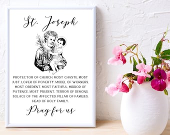 May include: Black and white printable art print featuring a drawing of Saint Joseph holding baby Jesus. The print includes the text "St. Joseph" and a prayer to Saint Joseph.