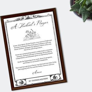 Peut inclure: Une impression d'art imprimable en noir et blanc avec une bordure ornée et une illustration stylisée d'un livre ouvert avec une plante qui en pousse. Le texte dit "Une prière d'étudiant" et comprend une prière attribuée à Saint Thomas d'Aquin.