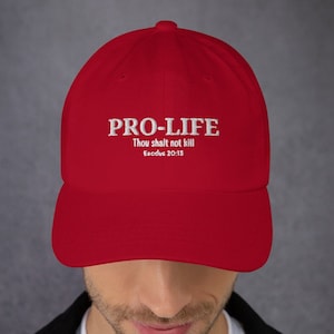 Puede incluir: Gorra de béisbol roja con bordado blanco que dice "PRO-LIFE Thou shalt not kill Exodus 20:13"