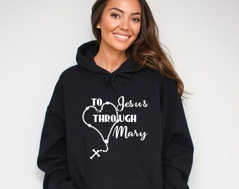 May include: Black hoodie with a white graphic design featuring a rosary in the shape of a heart with the text "To Jesus Through Mary".