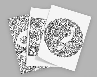 May include: Three rectangular colouring pages featuring black and white line art. The top page displays a scorpion centred within a circular mandala pattern. The two pages underneath feature intricate geometric and floral patterns in black ink.