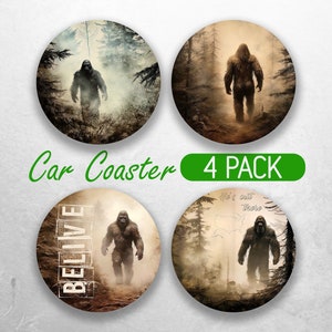 May include: Set of four round car coasters featuring a Bigfoot creature in a forest setting. The coasters have different designs, including one with the word "BELIEVE" and another with a map of the United States.