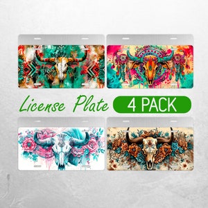 May include: Four pack of license plates featuring a colorful skull with horns and floral designs. The plates are white with a silver border.